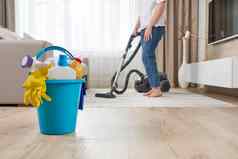 女人清洁地毯真空更清洁的生活房间