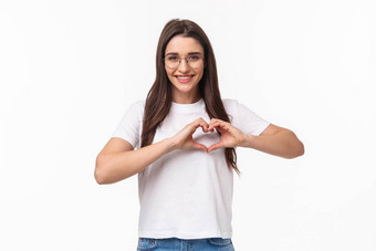 肖像有爱心的浪漫的可爱的年轻的女人眼镜t恤显示心标志微笑表达爱护理同情站白色背景开放心