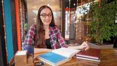 漂亮的学生女孩花时间阅读书咖啡馆灯运行客户走背景坐表格书镜头