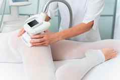 女人特殊的白色西装反脂肪团按摩腿水疗中心沙龙液化石油气身体轮廓线治疗诊所