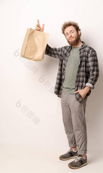 男人。格子衬衫持有棕色（的）纸袋孤立的白色背景交付概念纸袋外卖食物快递袋白色背景