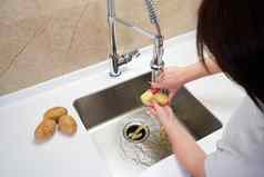 女手剥土豆食物浪费处分机水槽现代厨房