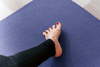 瑜伽女人伸展运动脚传播脚趾然后拉伸锻炼席