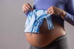 胃怀孕了女人蓝色的t恤婴儿男孩