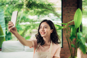 年轻的亚洲女人选取自拍照片智能<strong>手机首页</strong>