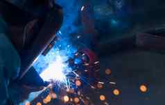 焊机焊接金属氩弧焊接机焊接火花男人。穿焊接面具安全工业工作场所焊机工作安全钢行业技术