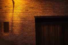 灯笼照亮晚上古董红色的砖墙空背景棕色（的）砖砌的坚固的砖砌的变形粗糙的表面