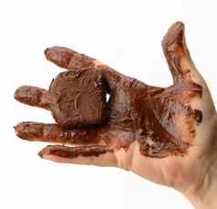 女手持有融化了一块黑暗巧克力手弄脏的巧克力白色背景