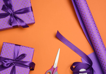 礼物盒子系紫色的丝绸<strong>丝带橙</strong>色<strong>背景</strong>前视图