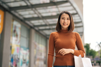 幸福消费主义出售人概念微笑年轻的亚洲女人购物袋户外购物购物中心