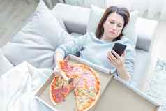 伤心女人吃披萨持有电话铺设沙发首页蓝色的语气