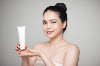 美概念亚洲漂亮的女人完美的皮肤持有化妆品瓶