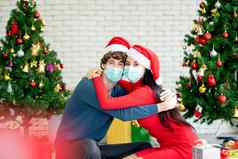 夫妇男人。女人卫生面具拥抱相机庆祝圣诞节节日流感大流行科维德