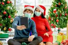 夫妇男人。女人卫生面具平板电脑庆祝圣诞节人家庭流感大流行科维德正常的生活方式