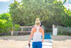 健身女人听音乐运动服装无线入耳式耳机夏天海洋海滩迈阿密
