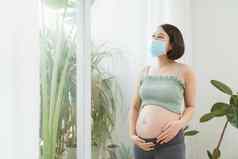 年轻的怀孕了女人保护医疗面具覆盖脸病毒保护卫生