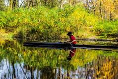 年轻的女人独木舟桨游泳河丛林