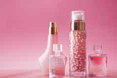香水瓶化妆过来这里粉红色的背景奢侈品美化妆品产品
