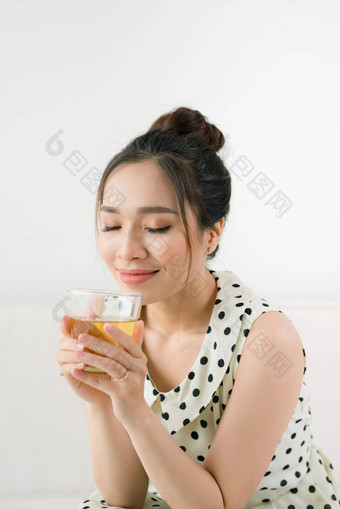 年轻的美丽的亚洲女人享受杯<strong>茶</strong>坐着<strong>首页</strong>