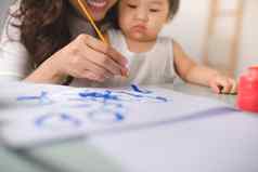 快乐家庭妈妈。女儿油漆亚洲女人帮助孩子女孩