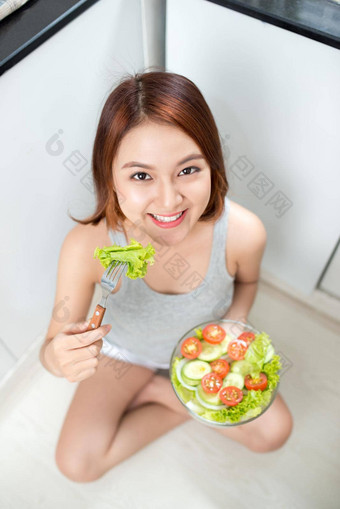 美丽的年轻的亚洲女孩吃沙拉微笑快乐女孩吃健康的食物