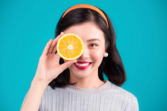 健康的食物微笑可爱的美女照片亚洲女孩持有橙色蓝色的<strong>背景</strong>