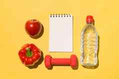 健身概念集合新鲜的水果哑铃水瓶黄色的背景