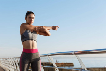 年轻的女运动员运动服装伸展运动身体慢跑锻炼女运动员站码头热身练习运行