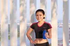 年轻的运动女人水瓶公园阳光明媚的一天体育运动健康的生活方式