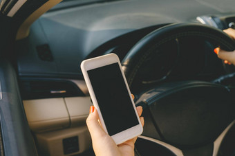 年轻的女司机触摸屏幕智能手机全球定位系统(gps)导航车