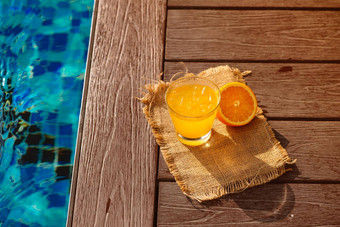 关闭螺丝刀鸡尾酒酒精喝橙色汁片冰站池让人耳目一新冰柠檬水饮料玻璃在游泳池边太阳的目光背景复制空间