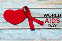 世界艾滋病一天意识标志红色的丝带战斗艾滋病标志蓝色的木背景