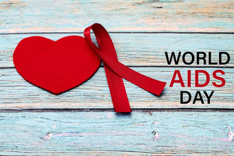世界艾滋病一天意识标志红色的丝带战斗艾滋病标志蓝色的木背景