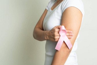 粉红色的徽章丝带女人手触碰胸部支持<strong>乳房癌症乳房癌症意识</strong>概念