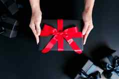 拳击一天出售概念女人手给礼物盒子黑色的背景