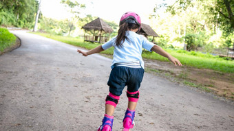 女孩穿保护垫安全头盔学习辊滑<strong>冰夏</strong>天公园活跃的户外体育运动孩子们