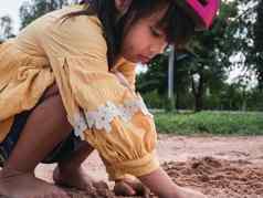 可爱的女孩头盔玩沙子公园阳光明媚的夏天一天采取打破骑自行车实践开发想象力探索