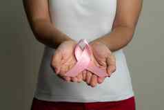 女人手持有粉红色的丝带乳房癌症意识