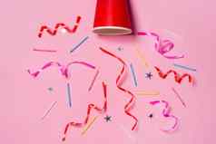 平躺庆祝活动纸杯色彩斑斓的聚会，派对飘带粉红色的背景