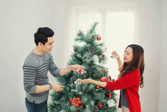 圣诞节亚洲夫妇快乐微笑家庭首页庆祝一年人