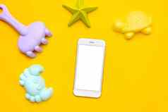 移动电话白色屏幕塑料海滩玩具柔和的颜色黄色的背景发展细电动机概念创造力游戏技术夏天概念