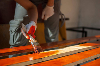 女工人使<strong>绘画作品</strong>木产品板材棕色（的）油漆使板凳上木匠工作木覆盖保护