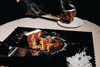 令人惊异的蛋糕black-gloved老板切片巧克力婚礼蛋糕婚礼蛋糕美味的内部黑色的背景大蛋糕白色巧克力