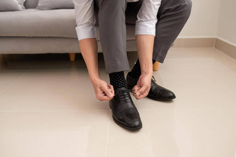 男人的手系鞋带鞋子人业务时尚鞋子概念关闭男人。腿手系鞋鞋带