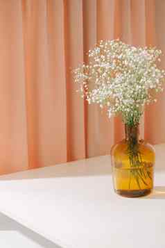 满天星婴儿的呼吸花玻璃瓶变形背景美丽的光艾里群众小白色花花生活室内装饰概念