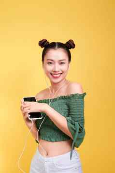 色彩斑斓的工作室肖像快乐年轻的亚洲女人耳机跳舞唱歌