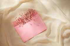 粉红色的信封春天花安排平躺前视图