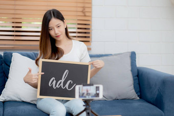 年轻的亚洲女人老师教学语言英语学生电子学习在线<strong>首页</strong>女孩工作会说话的教训类智能<strong>手机</strong>保持<strong>首页</strong>正常的教育概念