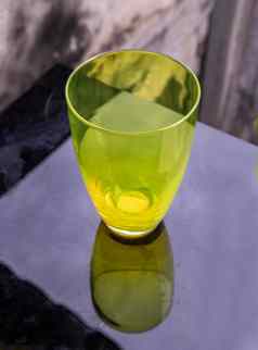彩色的透明的绿色玻璃杯水喝表面反射黑色的背景