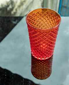 彩色的透明的红色的玻璃杯水喝表面反射黑色的背景
